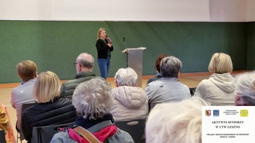 Prelegentka Małgorzata Nawrocik informuje o udogodnieniach dla seniorów