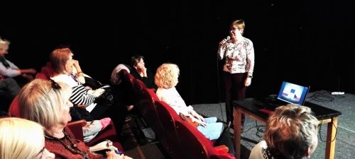 Na ekranie komputera gotowa prezentacja Marioli a Elżbieta Mikołajczak-Śmiśniewicz wita koleżanki i kolegów na kolejnym spotkaniu Klubu Podróżnika