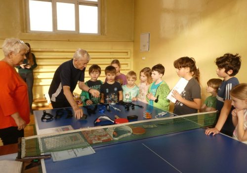 Instruktor Tadeusz Skibiński zapoznaje dzieci z zasadami gry w tenisa stołowego
